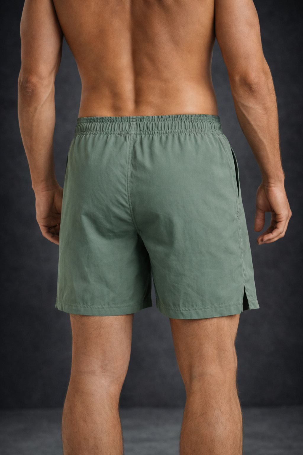 Man wearing green shorts and dark gray background
